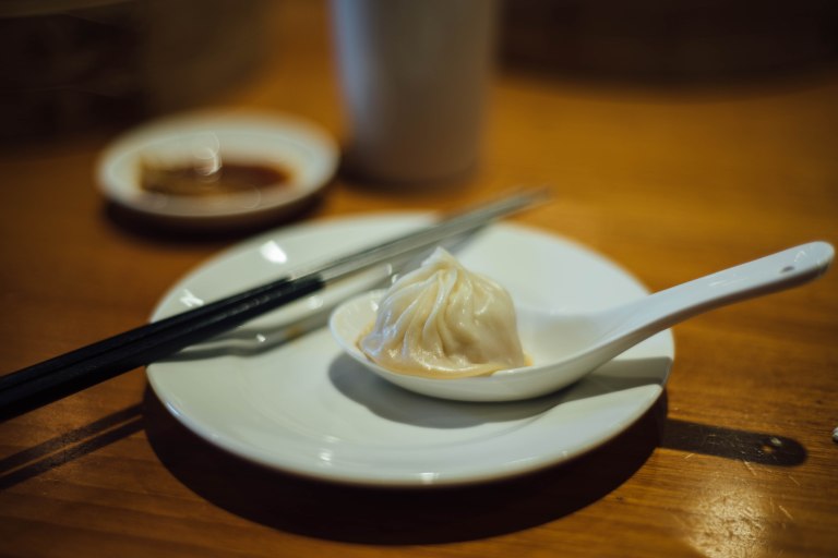 Eat xiao long bao over a spoon to catch the soup that pours out!